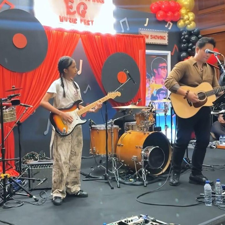 <p>Di momen itu, anak pertama dan kedua yang bernama Aqilah dan Aqlan kembali mengejutkan sang ayah dengan tampil di atas panggung membawakan sebuah lagu. Aqila terlihat memainkan gitar, sedangkan Aqlan menjadi drummer.&nbsp;(Foto: Instagram@mrsayudewi)</p>