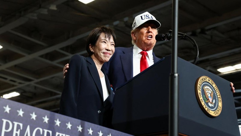 Presiden AS Donald Trump berbicara sementara Perdana Menteri Jepang Sanae Takaichi memberi isyarat kepada personel militer, di atas kapal induk USS George Washington, selama kunjungan mereka ke pangkalan Angkatan Laut AS di Yokosuka, Jepang, 28 Oktober 2025. (REUTERS/Kim Kyung-Hoon)