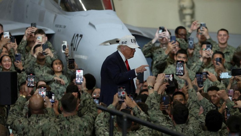 Presiden AS Donald Trump berbicara sementara Perdana Menteri Jepang Sanae Takaichi memberi isyarat kepada personel militer, di atas kapal induk USS George Washington, selama kunjungan mereka ke pangkalan Angkatan Laut AS di Yokosuka, Jepang, 28 Oktober 2025. (REUTERS/Kim Kyung-Hoon)
