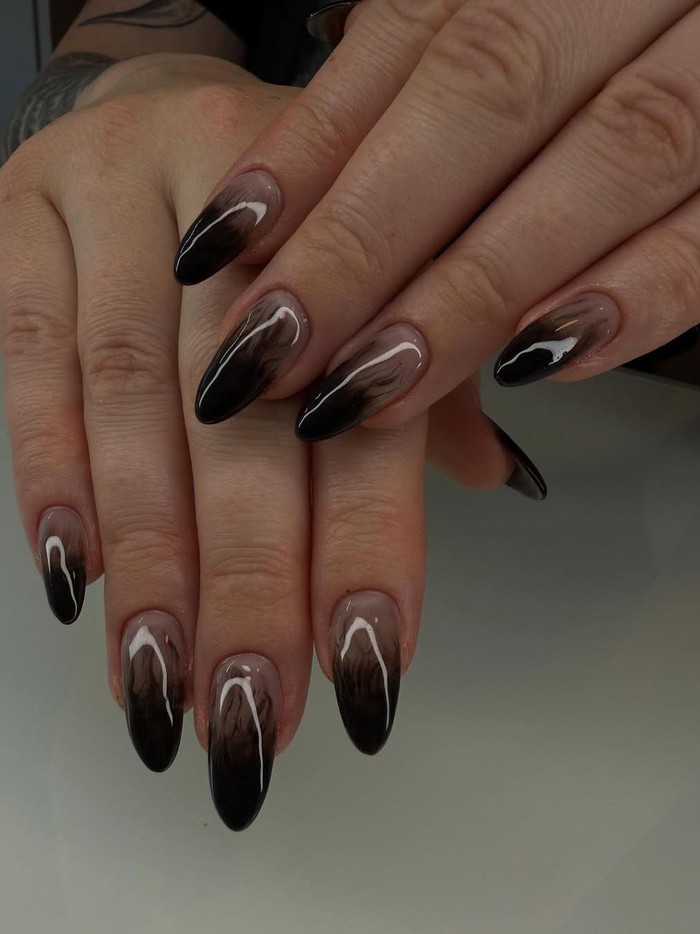Ingin tampil elegan tapi tetap misterius? Smokey nails dengan efek kabut hitam di atas dasar nude bisa jadi pilihan sempurna untuk Halloween. Gaya ini juga cocok untuk pemilik kuku pendek./ Foto: instagram.com/nailboutiquebykc