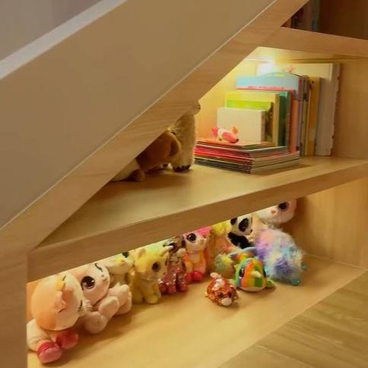 <p>Di sebelah tempat tidur atau di bawah perosotan, Franda membuat rak kecil yang berisi buku-buku serta boneka milik kedua anaknya. Rak ini dibuat dengan desain kayu cokelat dan diterangi oleh cahaya lampu kuning. (Foto: Instagram @frandaaa87)</p>