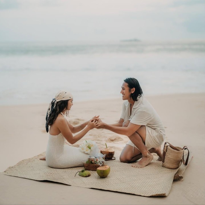 <p>Momen romantis saat Sean melamar Hana dibagikan di Instagram. Bak di film romantis, Sean melamar kekasihnya itu di pinggir pantai dengan suasana yang aesthetic. Dalam potret yang dibagikan, Sean dan Hana kompak mengenakan pakaian berwarna putih gading. Keduanya terlihat sedang menikmati waktu bersama di pinggir pantai. (Foto: Instagram @gelaelized)</p>