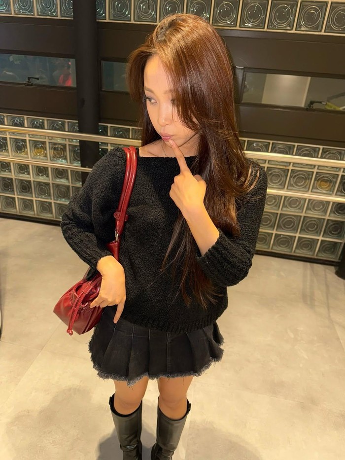 Memberikan kesan casual-feminin, Dita Karang memadupadankan knit cardigan, mini skirt, dan leather boots berwarna hitam. Sebagai pemanis, ia menambahkan sling bag berwarna merah menyala./ Foto: instagram.com/hey__deets