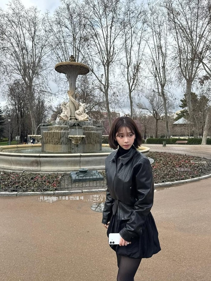 Cocok untuk inspirasi outfit liburan, Karina aespa mengenakan balloon skirt berwarna hitam yang dipadukan dengan inner, stocking, serta leather jacket berwarna serupa./ Foto: instagram.com/katarinabluu