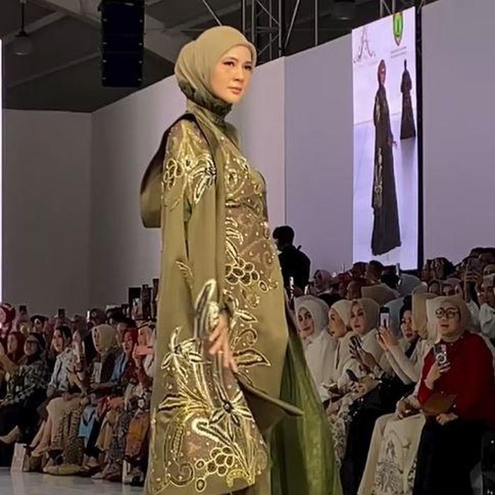 <p>Di JFW kali ini, Paula tampil cantik mengenakan dress panjang berwarna hijau yang dipadukan dengan <em>top cape</em> bernuansa warna kecokelatan bermotif dedaunan. Bunda dua anak ini terlihat begitu anggun dan luwes saat berjalan memamerkan baju yang dikenakannya. (Foto: Instagram @ayudyahandari)</p>