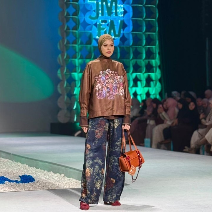 <p>Masih dari <em>brand</em> yang sama, <em>modest look</em> kali ini tampil begitu <em>classy</em> dengan atasan berwarna <em>deep mahogany</em> lengkap dengan motif bunga di bagian tengah. Dipadukan dengan celana bermotif, gaya ini terlihat begitu elegan. Bisa jadi inspirasi menarik buat Bunda yang suka tampil anggun. (Foto: Nadhifa Fitrina)</p>