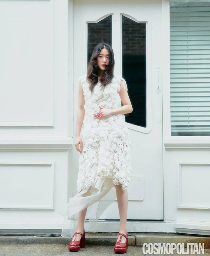 Tampil anggun dalam balutan dress putih dengan detail bunga tiga dimensi yang membuatnya lebih dreamy. Ia juga memadukannya dengan heels merah glossy yang jadi statement bold untuk terlihat elegan dan feminin./ Foto: Instagram.com/choisungeun.official