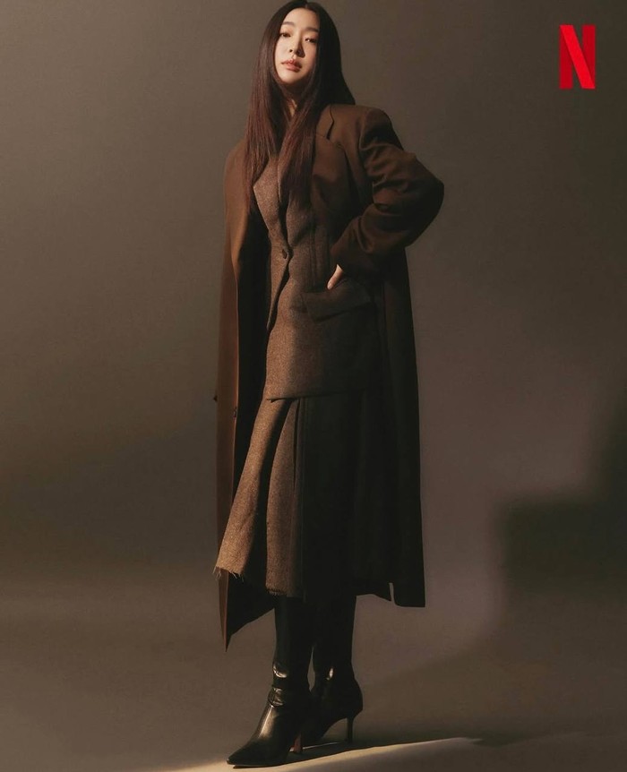 Terlihat powerful dengan setelan blazer dan rok midi tebal yang berwarna cokelat tua. Ia juga memadukannya dengan long coat oversized dan boots heels hitam untuk tampil elegan dan memberikan kesan ‘bossy’./ Foto: Instagram.com/choisungeun.official