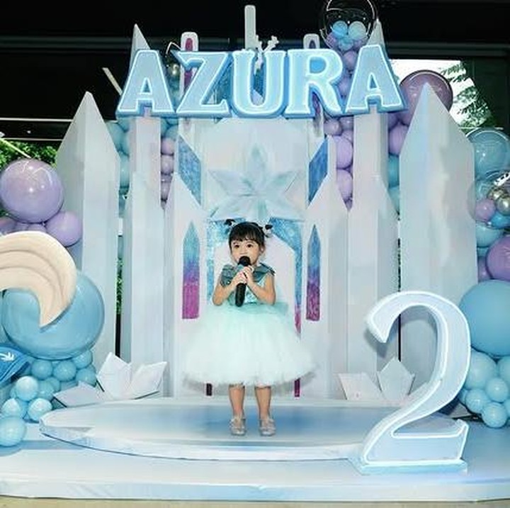 <p>Di hari spesialnya, Azura tampil begitu menggemaskan mengenakan <em>dress </em>berwarna biru muda bak karakter Elsa dalam film <em>Frozen</em>. Rambutnya yang dicepol dua membuat penampilannya semakin manis, Bunda. (Foto: Instagram @attahalilintar)</p>