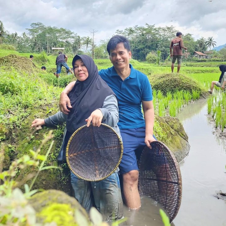<p>Ayah dan Bunda Lesti membagikan momen saat berada di pinggir sawah melalui unggahan di Instagram. Keduanya terlihat berdiri di genangan air berlumpur sambil memegang tampah bambu. "Inilah kami," tulis ayah Lesti. (Foto: Instagram @ayah_kejora)</p>