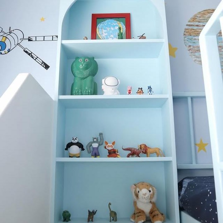 <p>Di dekat kasurnya, terdapat rak bertingkat yang mampu menampung berbagai mainan dan koleksi sang anak dengan desain yang menarik. Warna rak ini juga disesuaikan dengan tema kamar, Bunda. (Foto: Instagram @melodyprima)</p>