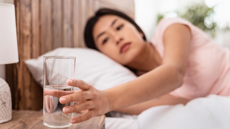 Healthy Liquid. Asian Lady Drinking Water From Glass Starting Day With Hydration Lying In Bed At Home. Selective Focus