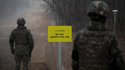 In a photo taken on December 3, 2018 South Korean soldiers stand before the Military Demarcation Line (MDL) separating North and South Korea, on the southern side of the Demilitarized Zone (DMZ) in South Korea's Cheorwon county. North and South Korea