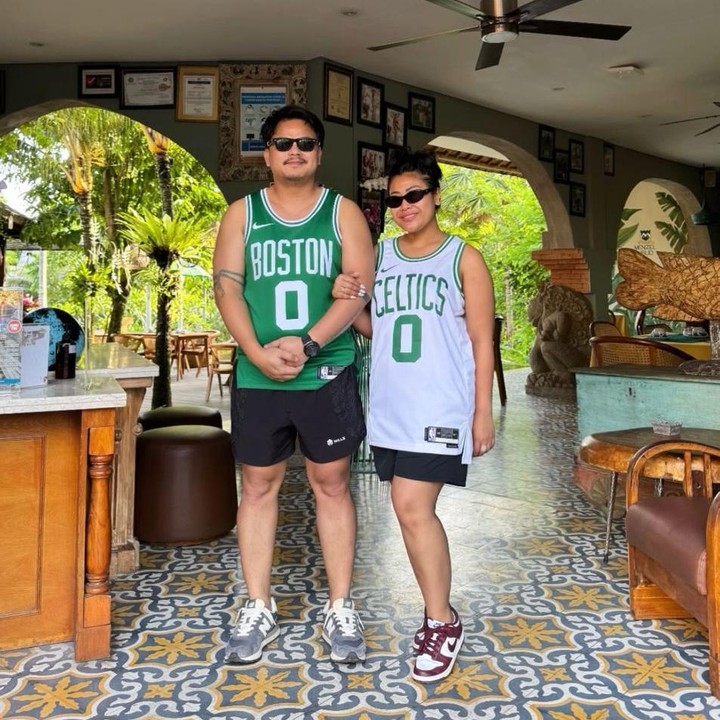 <p>Menariknya, ia dan sang suami tampil serasi mengenakan pakaian yang sama, yakni model baju basket lengan pendek berwarna hijau dan putih. Penampilan keduanya pun tampak kece dilengkapi dengan kacamata hitam.&nbsp;(Foto: Instagram @boiyenpesek)</p>