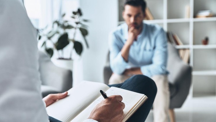 Young frustrated man solving his mental problems while having therapy session with psychologist