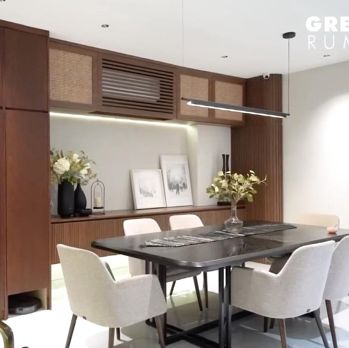 <p>Di dekat ruang keluarga, pasangan ini membangun dapur bersih dan meletakkan meja makan keluarga yang cukup besar. Konsep dapur dan meja makan ini juga masih didominasi kayu cokelat dengan beberapa furnitur minimalis. (Foto: YouTube AH)</p>
