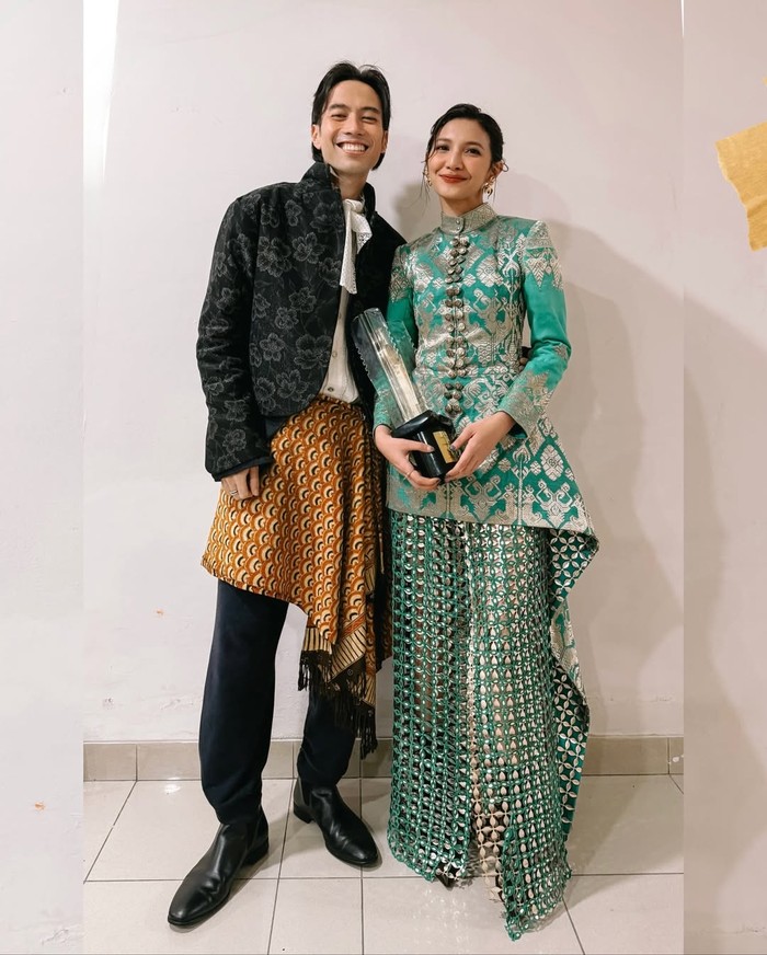 Vidi Aldiano dan Sheila Dara Aisha serasi mengenakan wastra. Vidi tampak stylish dalam balutan outfit dari Tanah Le Saé. Kemeja putiih berkerah pita ditumpuk dengan jaket hitam motif bunga, sedangkan sentuhan budaya diperoleh dari kain batik sebagai overlay celana. Sementara sang Pemenang Aktris Terbaik FFI 2025 mengenakan rancangan Sapto Djojokartiko yang di-styling oleh Hagai Pakan. Busana Sheila penuh detail memesona, mulai dari songket Bali dengan benang emas, rok bermotif Kawung, hingga atasan dengan ekor asimetris/ Foto: Instagram.com/vidialdiano