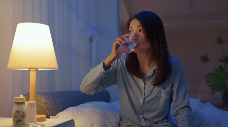 closeup asain woman take medicine before going to bed - she need to take sleeping pills