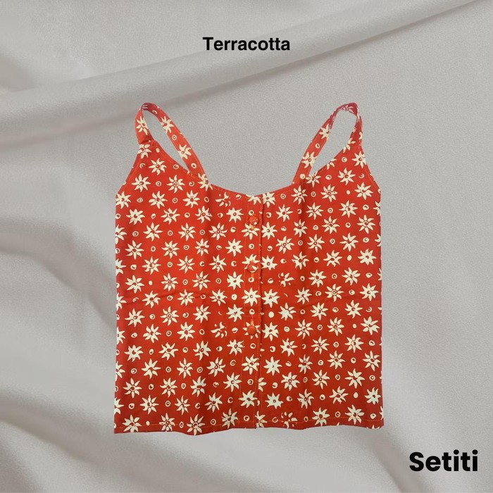 Tank top dari brand ARTI SETITI, Mbarep Series, berwarna terracota cerah. Tank top ini terbut dari bahan katun dengan proses batik cap.