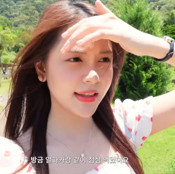 <p>Hari ketiga, perempuan 19 tahun ini tampil cantik mengenakan <em>mini dress</em> berwarna putih dengan motif bunga merah. &ldquo;Semuanya, aku akan bersenang-senang bermain dengan alpaca hari ini. Cuacanya sangat bagus dan sejuk, jadi tidak panas,&rdquo; jelasnya.&nbsp;(Foto: YouTube Hearts2Hearts)</p>