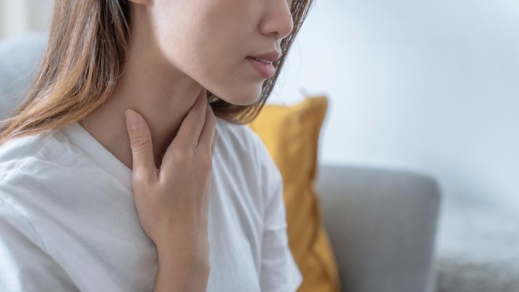 Asian woman suffering from sore throat, Acid reflux.