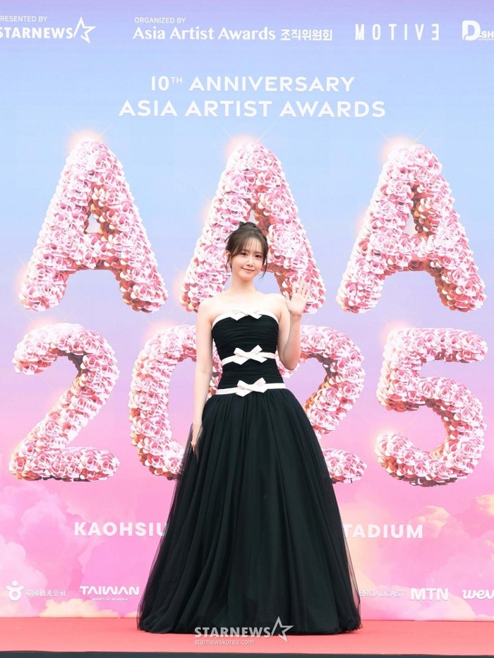 Selain Hyeri, idol-aktris Yoona juga memancarkan aura elegan di red carpet Asia Artist Awards 2025 dalam balutan sleeveless dress dengan detail pita di bagian pinggang./ Foto: StarNews