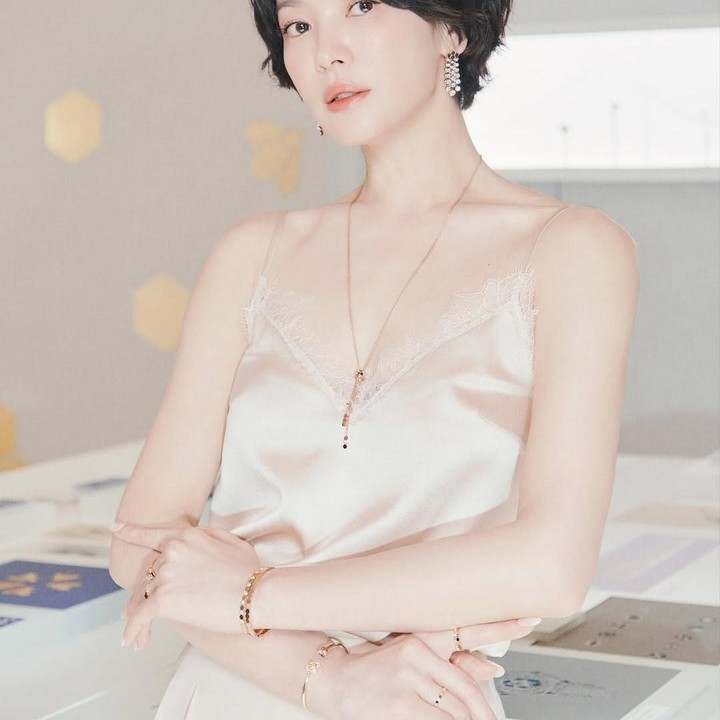 <p>Looks short wavy bob terlihat sangat cocok dipadukan dengan outfit minimalis. Terlihat pada potret ini, Song Hye Kyo mengenakan top yang hampir senada dengan kulitnya disertai kalung emas yang memberikan aksen mewah. (Foto: Instagram @kyo1122)</p>