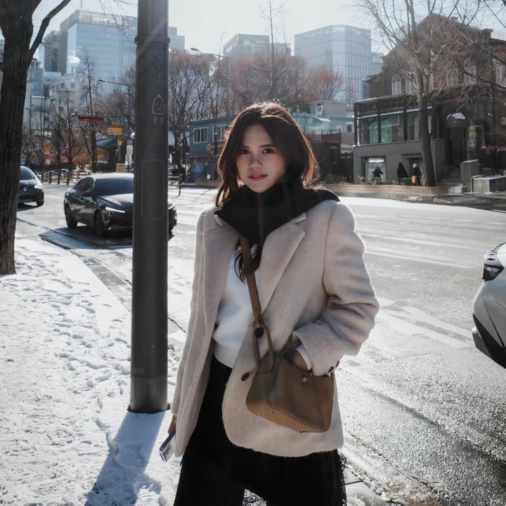 <p>Dalam satu foto di tengah musim salju di Korea, Audi tampak mengenakan sweeter putih dan celana hitam. Perempuan kelahiran Jakarta ini menyempurnakan OOTD-nya dengan jaket tebal berwarna krem muda yang dipadukan dengan syal berwarna gelap dan tas cokelat bernuansa <em>vintage</em>. (Foto: Instagram @audimarissa)</p>