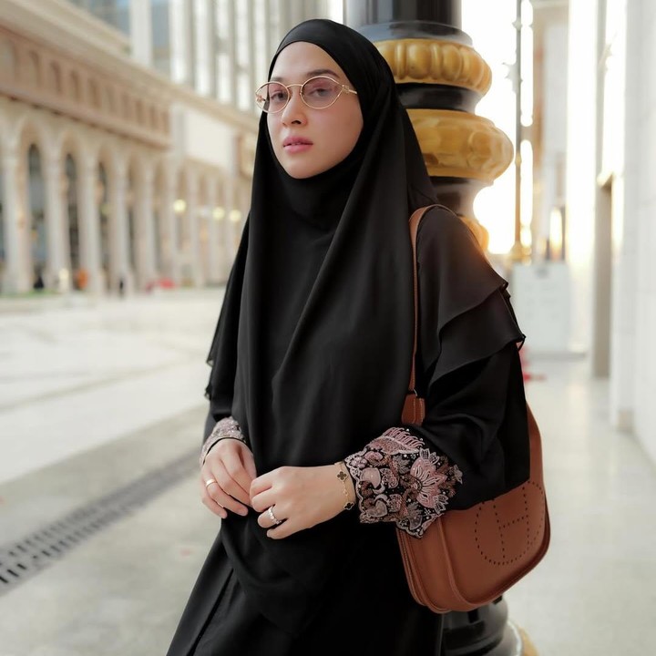 <p>Artis cantik Nina Zatulini sebentar lagi dikaruniai anak keempat. Belum lama ini, Nina bersama suami dan ketiga anaknya menunaikan ibadah umrah. Saat berada di Tanah Suci, gaya <em>chic</em> Nina mencuri perhatian netizen. Nina tampil kece karena berhasil padu padan jilbab hitam dengan gamis hitam bermotif bunga. Nina menyempurnakan penampilannya yang <em>stylish</em> dengan kacamata dan tas kulit berwarna cokelat. (Foto: Instagram @ninazatulini22)</p>