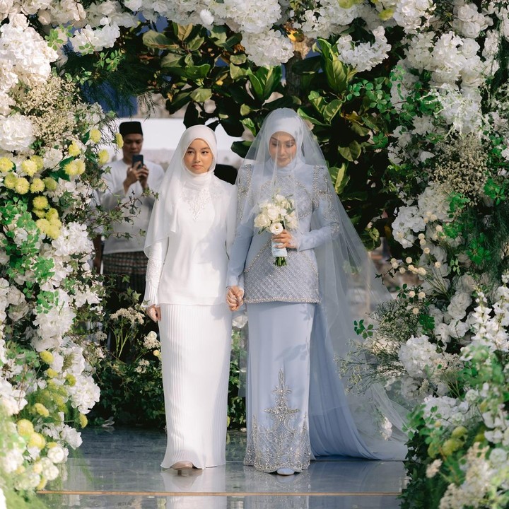 <p>Pernikahan dimulai saat Erra memasuki tempat akad nikah. Dalam potret yang dibagikan di Instagram, Erra terlihat didampingi sang putri semata wayangnya Engku Aleesya. Di pernikahan sang Bunda, Aleesya tampil cantik mengenakan pajaian serba putih. (Foto: Instagram @ezwanzain/ @errafazira)</p>
