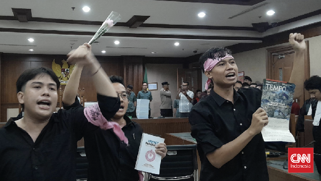 Aktivis Delpedro Marhaen memberikan bunga kepada JPU dan hakim sebelum sidang kasus penghasutan demonstrasi.