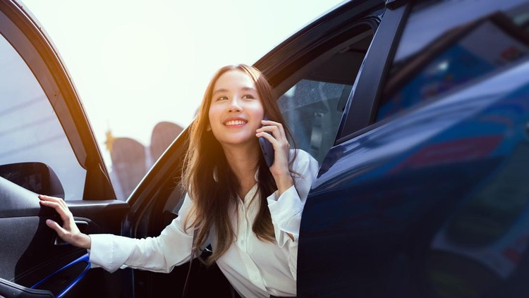 Confidence of asian business woman getting out of the car her use mobile phone calling in the modern city&period; people lifestyle&period;