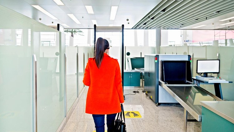 Female passenger walking through the airport security checkpoint