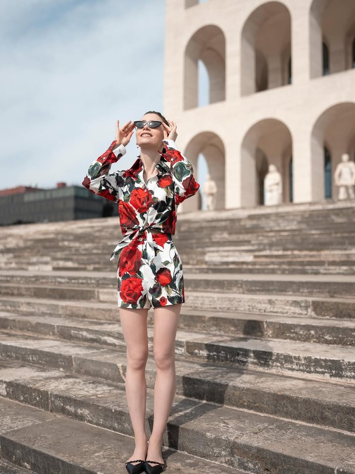 Emily Cooper terlihat bergaya semi-formal dengan atasan model tie front dan celana pendek motif floral dari Dolce & Gabbana./ Foto: Instagram.com/netflix