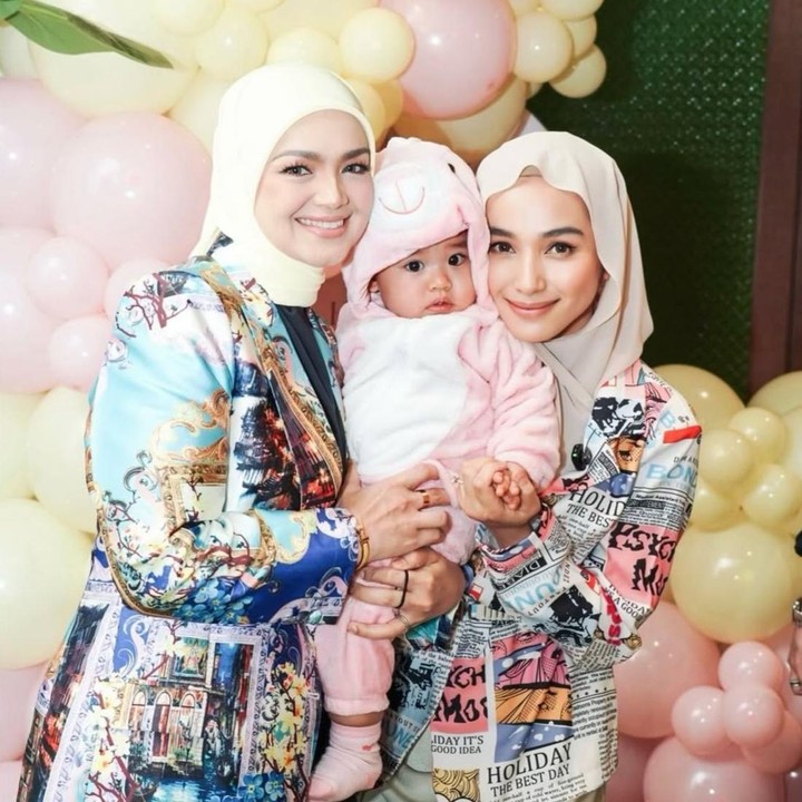 <p>Sejak kelahirannya, Aghnia selalu berhasil mencuri perhatian netizen, Bunda. Terlebih lagi saat momen kebersamaannya dengan sang nenek, Siti Nurhaliza. Seperti pada potretnya ini, sang nenek tampak hadir dalam perayaan ulang tahun pertama Aghnia. (Foto: Instagram @tyaarifinnw)</p>