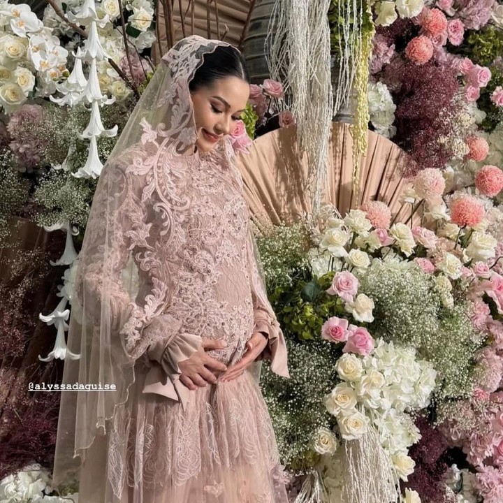 <p>Dalam acara tasyakuran kehamilan ini, Alyssa tampil cantik mengenakan gaun berwarna rose pink dengan aksesoris kerudung berbahan lace motif bunga yang warnanya senada dengan gaun. Dalam balutan gaun cantik ini, Alyssa memamerkan <em>baby bump</em> kehamilannya yang mulai terlihat jelas. (Foto: Instagram @alyssadaguise)</p>