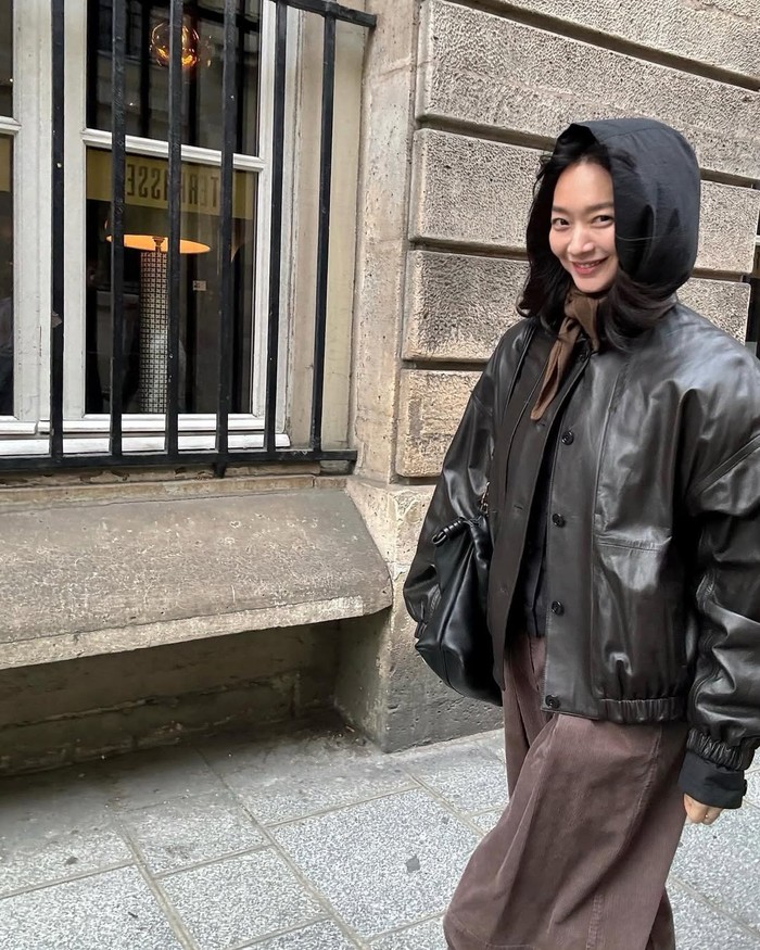 Gaya kasual digunakan saat traveling di Paris, Prancis. Shin Min Ah kenakan leather jacket saat musim gugur.