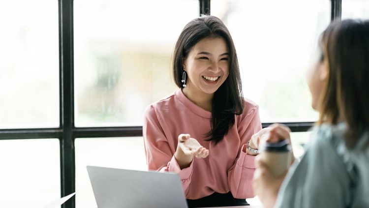 Two Asian business woman in conference room&comma; Two beautiful business woman smiling happy and confident&period; Sitting with smile on face working together using laptop at the office&period;
