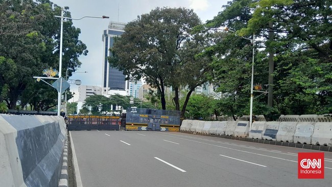 Aparat kepolisian menutup Jalan Medan Merdeka Selatan, Jakarta Pusat seiring dengan aksi demonstrasi yang dilakukan oleh serikat buruh, Selasa (30/12).