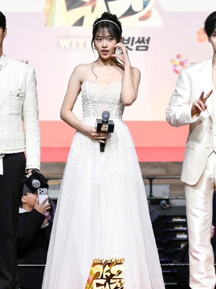 Ahn Yu Jin memukau publik berkat penampilan cantiknya yang memancarkan aura mahal dalam balutan strapless dress berpotongan panjang dengan aksen bunga di bagian atasnya ketika menjadi MC SBS Gayo Daejeon pada (25/12/2025)./ Foto: instagram.com/sbsgayo_official