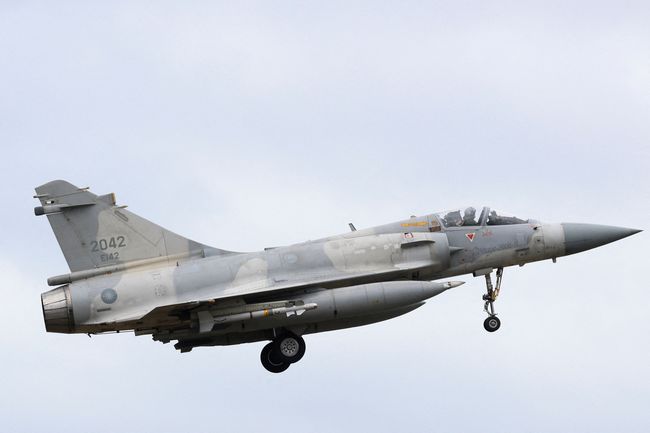 A person takes a photo of a flight information display screen that shows cancelled flights at the Taipei Songshan Airport, as China conducts