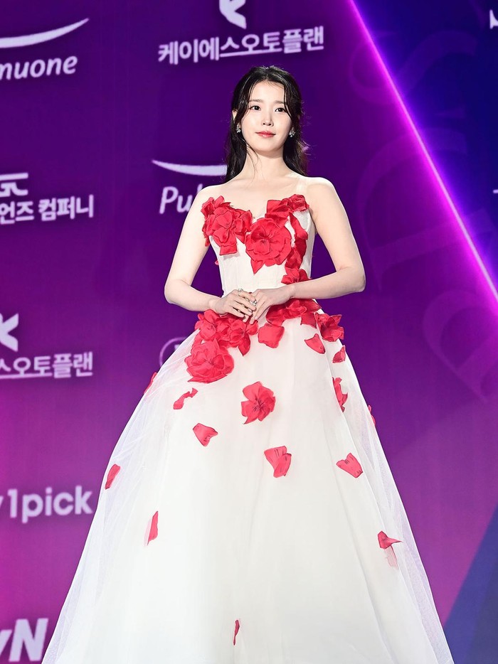 Indah layaknya buket bunga mawar, aktris-penyanyi IU tampil menawan dalam balutan sleevesless dress dengan detail bunga merah yang memikat./ Foto: XPN/soompi.com