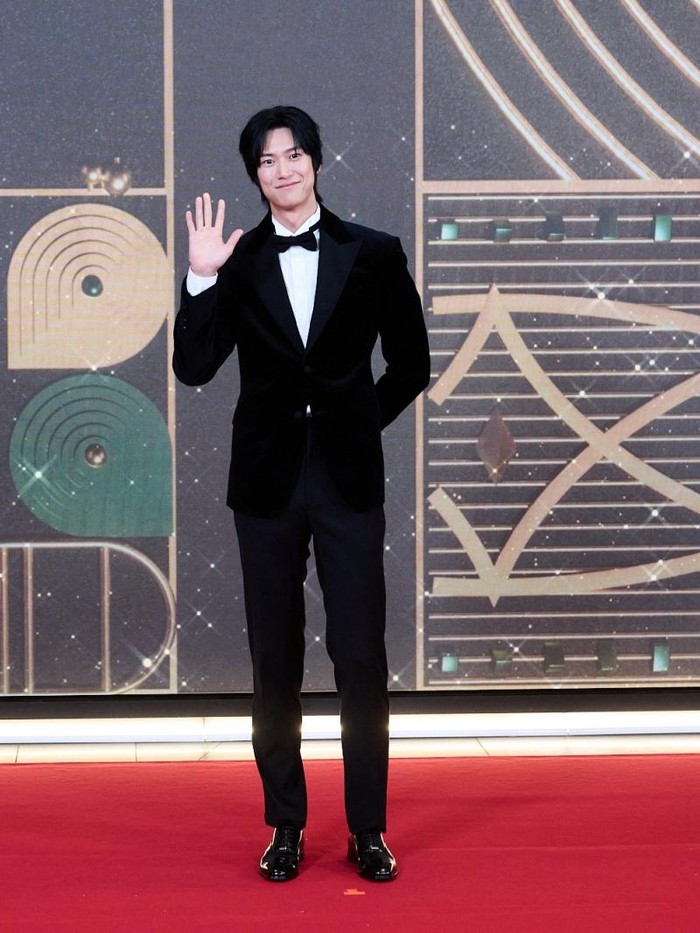 Na In Woo tampil dengan gaya rambut gondrong dengan setelan jas hitam, senada dengan dasi kupu-kupu yang dipakainya./ Foto: soompi.com