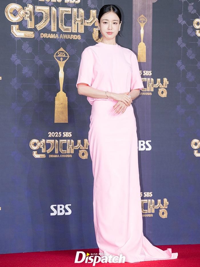 Ahn Eun Jin tampil cerah dengan one piece dress bewarna pink terang yang bagian atasnya menekankan kesan santai dan bagian bawah rok panjang tersebut mengalirkan energi feminin yang cocok dengan riasan manis sang aktris./ Foto: dispatch.co.kr