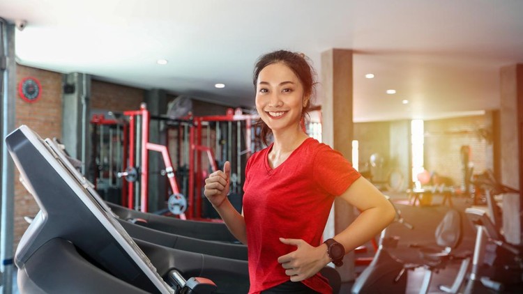 Asian young woman is having jogging on the treadmill