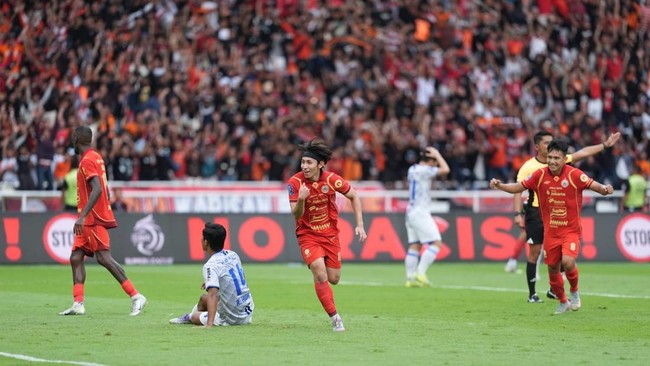 Pelatih Persija, Mauricio Souza, tersenyum genit mendengar jawaban pemainnya tentang atmosfer laga melawan Persib.