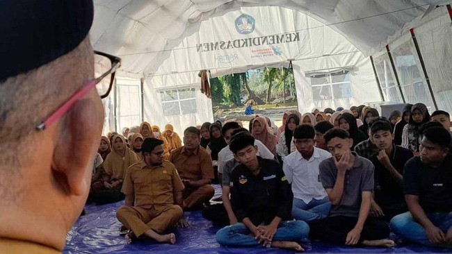 Pelajar SMA Negeri 2 Pidie Jaya belajar di tenda akibat sekolah tertimbun lumpur. Proses belajar mengajar dimulai meski banyak siswa kehilangan peralatan.