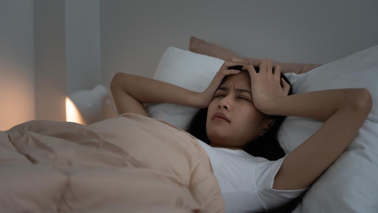 asian woman in bed late trying to sleep suffering insomnia&comma; sleepless or scared in a nightmare&comma; looking sad worried and stressed&period; Tired and headache or migraine waking up in the middle of the night&period;