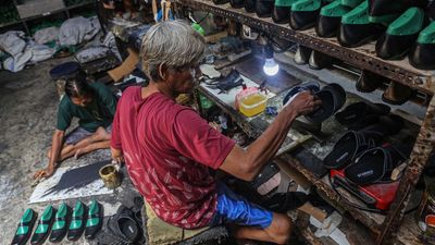 Dua pekerja menyelesaikan pembuatan alas kaki sandal kulit di rumah industri sepatu, Rejomulyo, Semarang, Jawa Tengah, Selasa (6/1/2026). Pemerintah resmi menanggung Pajak Penghasilan (PPh) Pasal 21 y