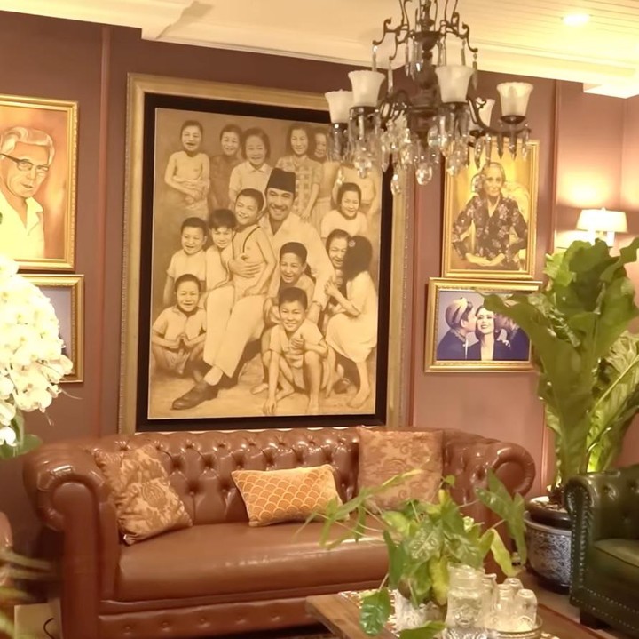 <p>Yuni juga memperlihatkan area ruang tamu yang didominasi dengan warna teracota. Ia pun melengkapi dinding ruangan tersebut dengan lukisan lelang yang dibuat oleh anak-anak santri. &ldquo;Ini adalah lukisan lelang yang dilukis anak-anak santri. Sebenarnya waktu zaman Indonesia lagi dilanda bencana berentetan, aku tuh jadi tukang lelang,&rdquo; ungkapnya.&nbsp;(Foto: YouTube Melaney Ricardo)</p>